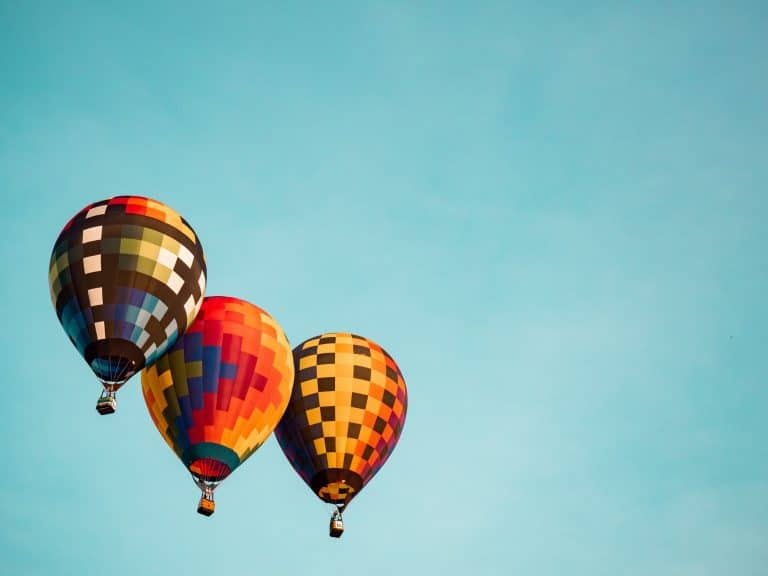 three hot hair balloons against a blue sky