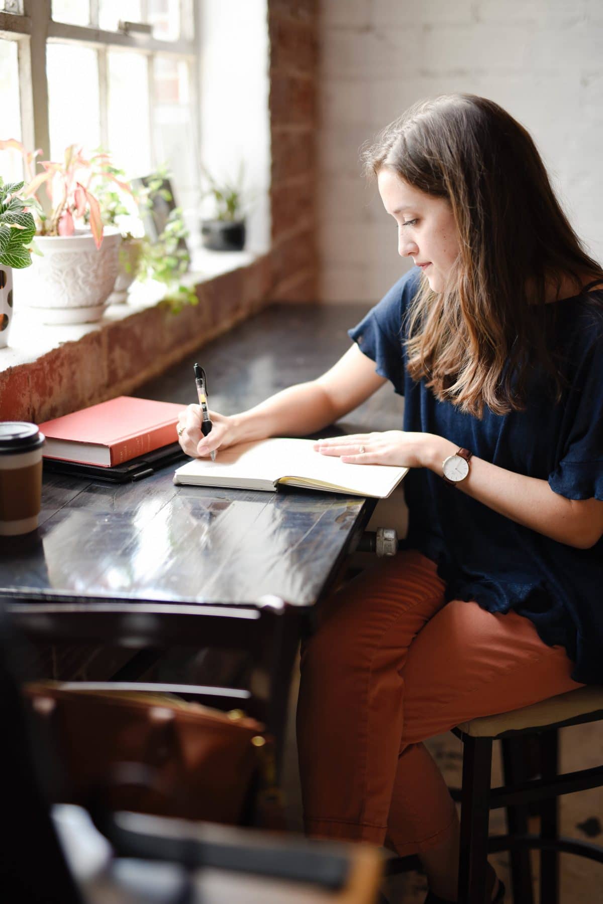 woman sitting at a desk writing in a notebook