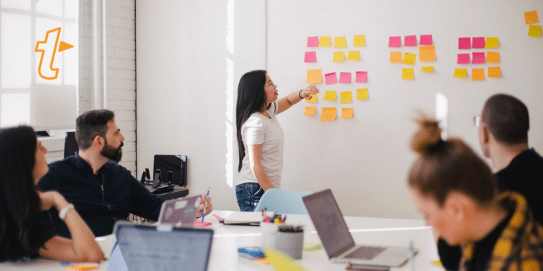 woman placing sticky notes on whiteboard