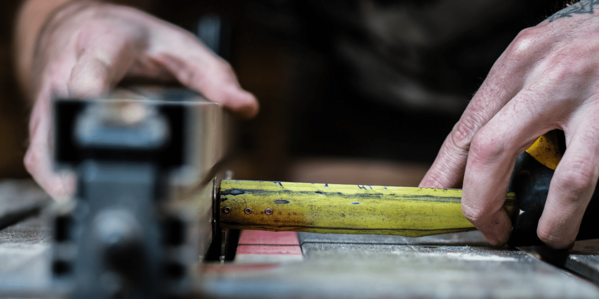 Hands measuring with a tape measure at a workbench, representing building a customer service policy