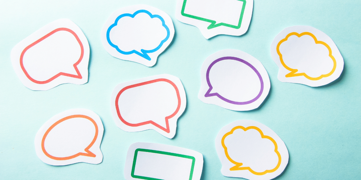 Colorful blank paper speech bubbles scattered on a light blue background