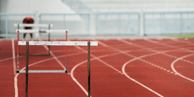 Hurdles lined up on a red running track