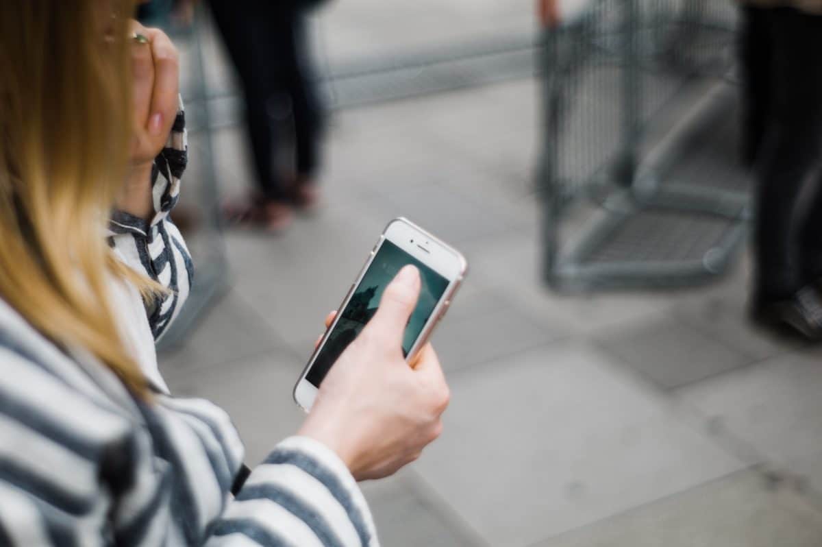 Person holding a smartphone while reading a recruiting text message.