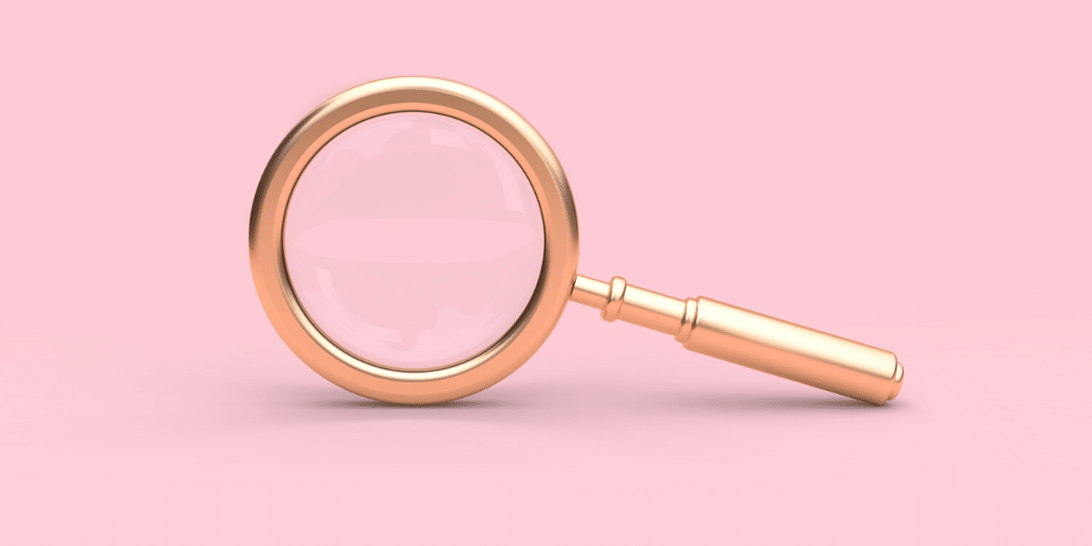 A magnifying glass on a pink background