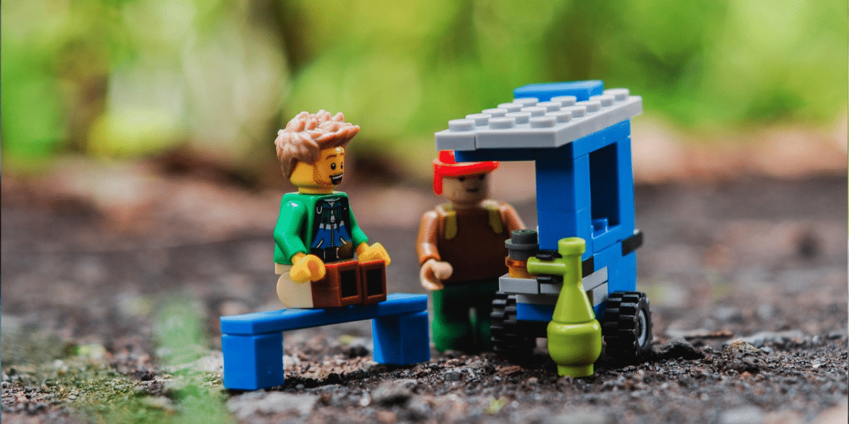 Lego minifigures at a small blue Lego cart, playfully depicting a customer and vendor