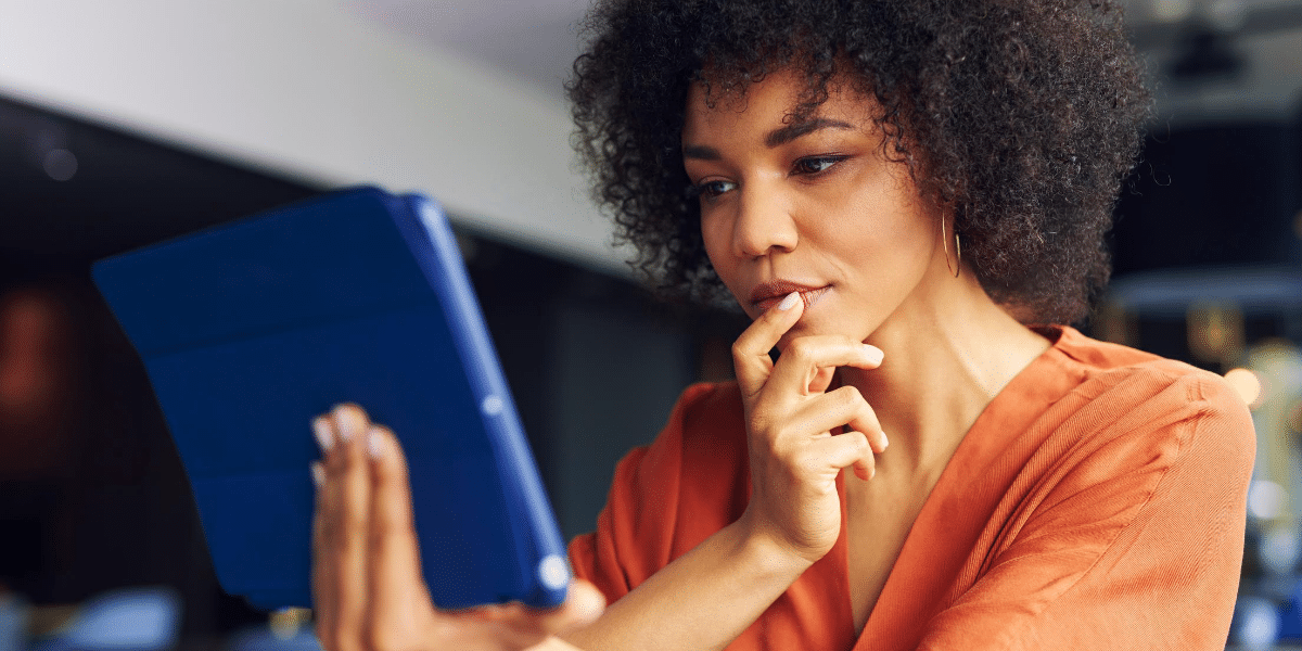 woman in an orange top looking at screen