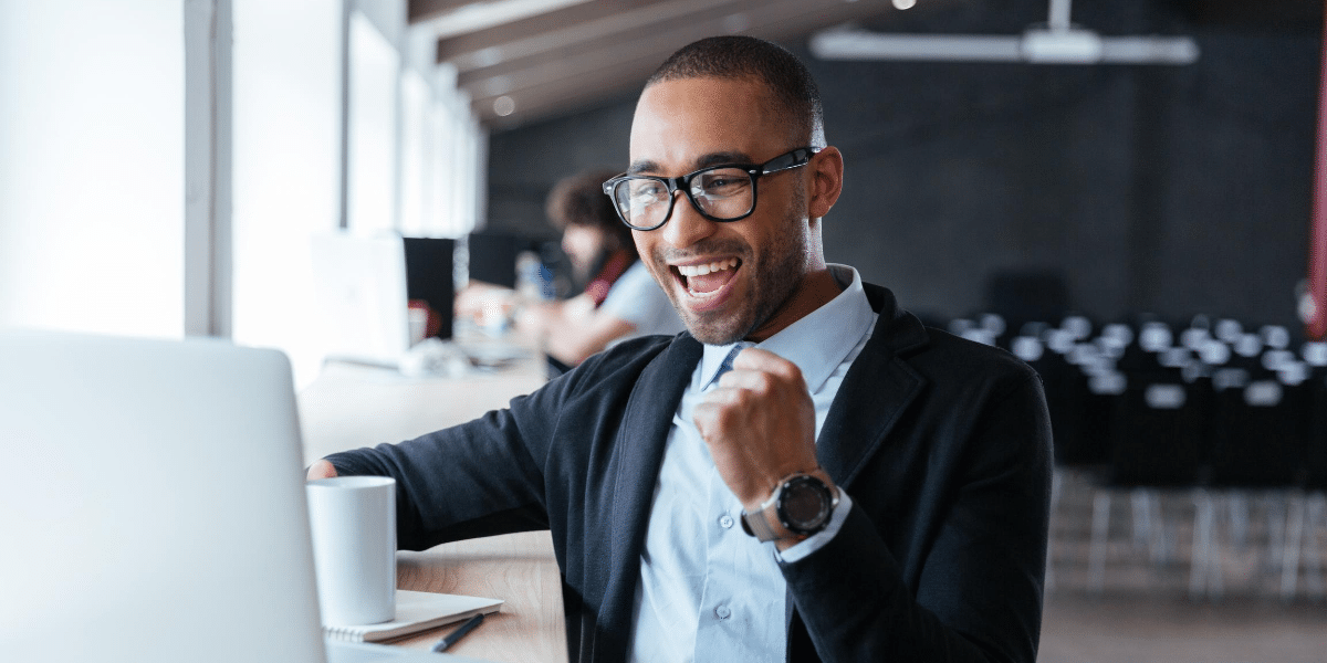 man at desk celebrating