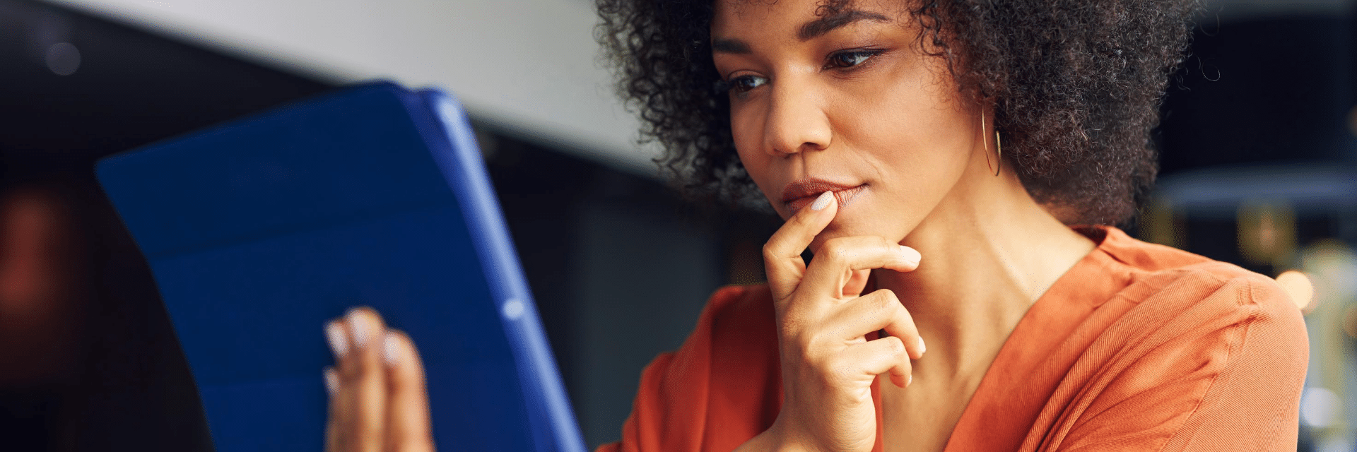 woman in an orange top looking at screen