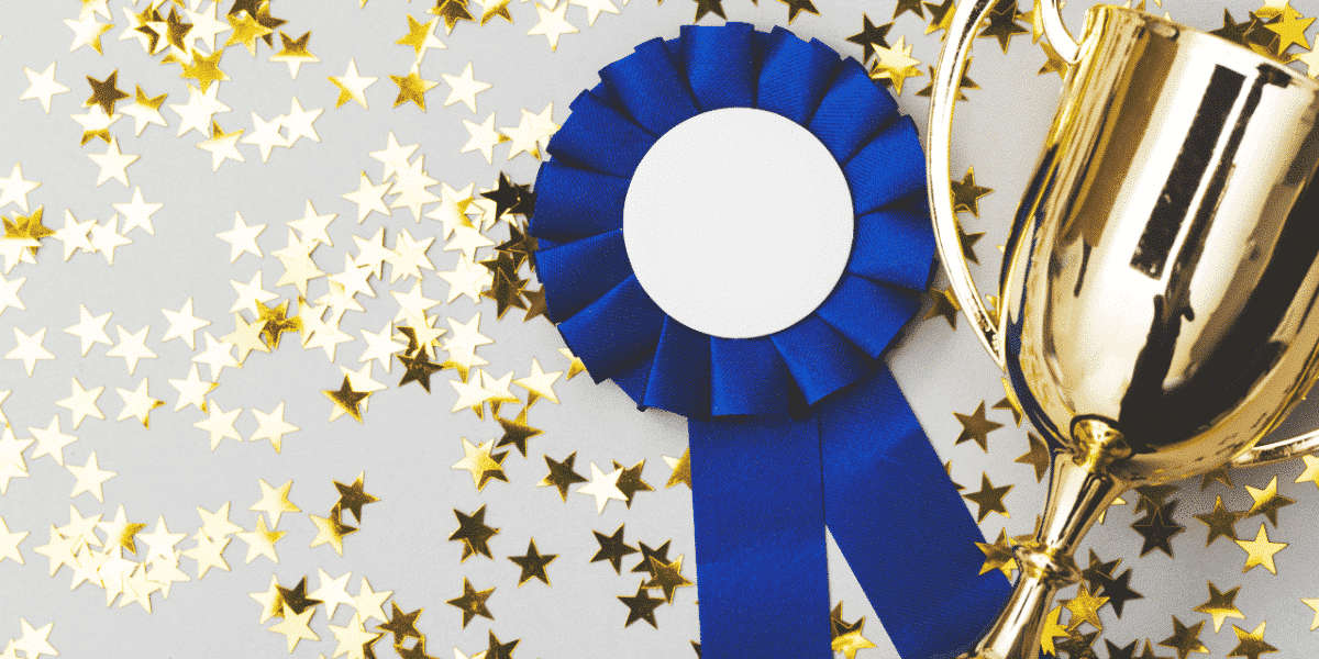 trophy and rosette with gold stars sprinkled around