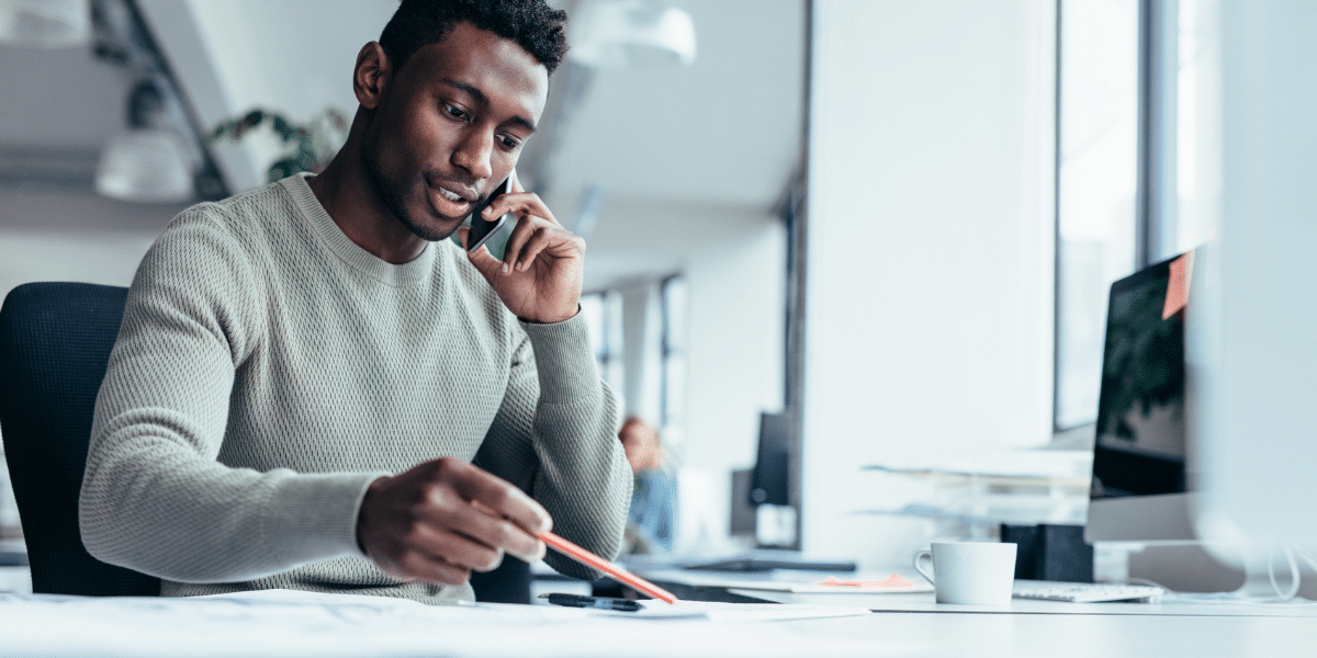 man on the phone writing notes