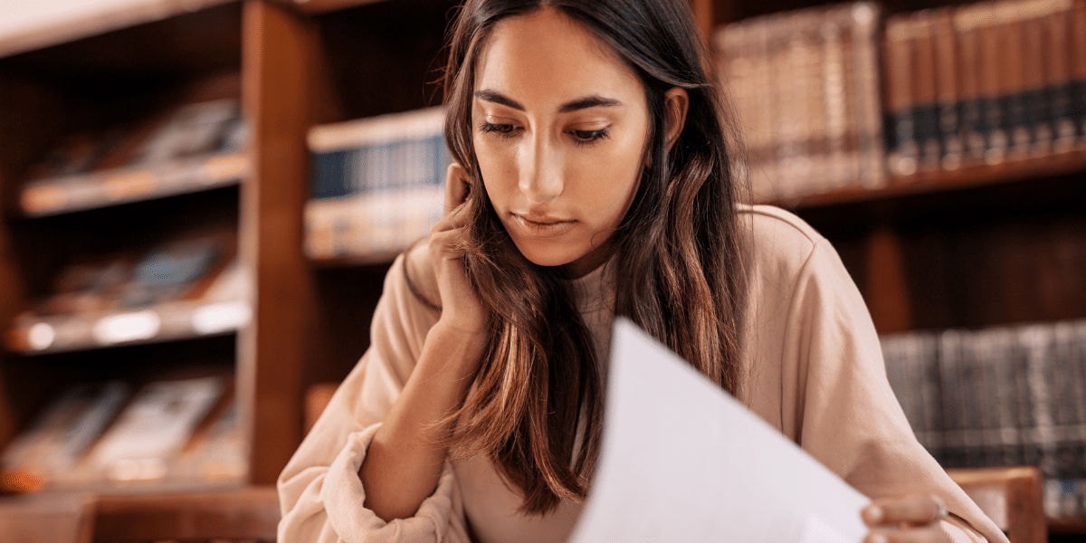 female reading a document in a library