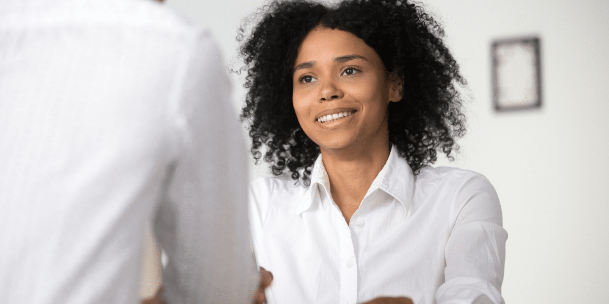 woman shaking person's hand