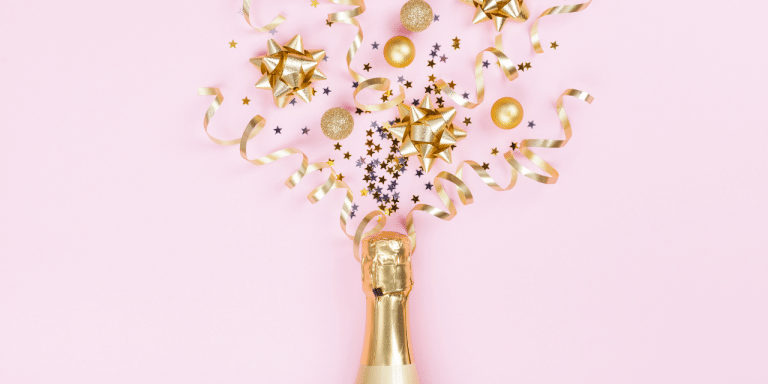 champagne with confetti popping out on pink background