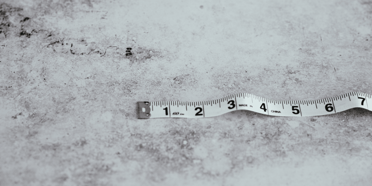 Measuring tape lying on a grey concrete surface