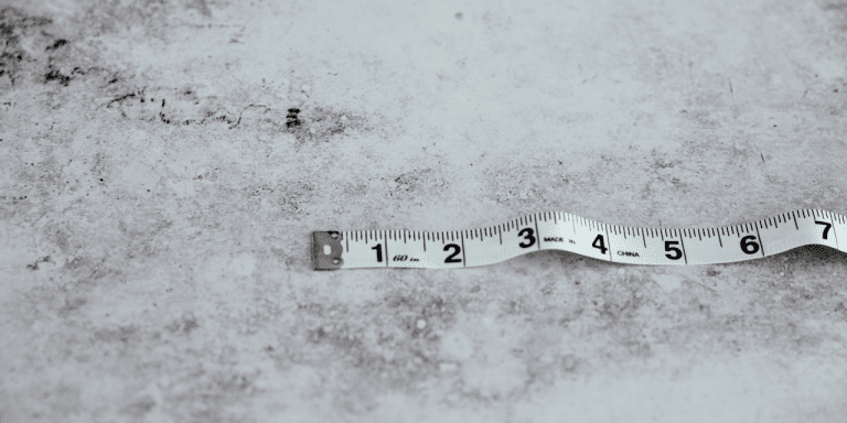 Measuring tape lying on a grey concrete surface