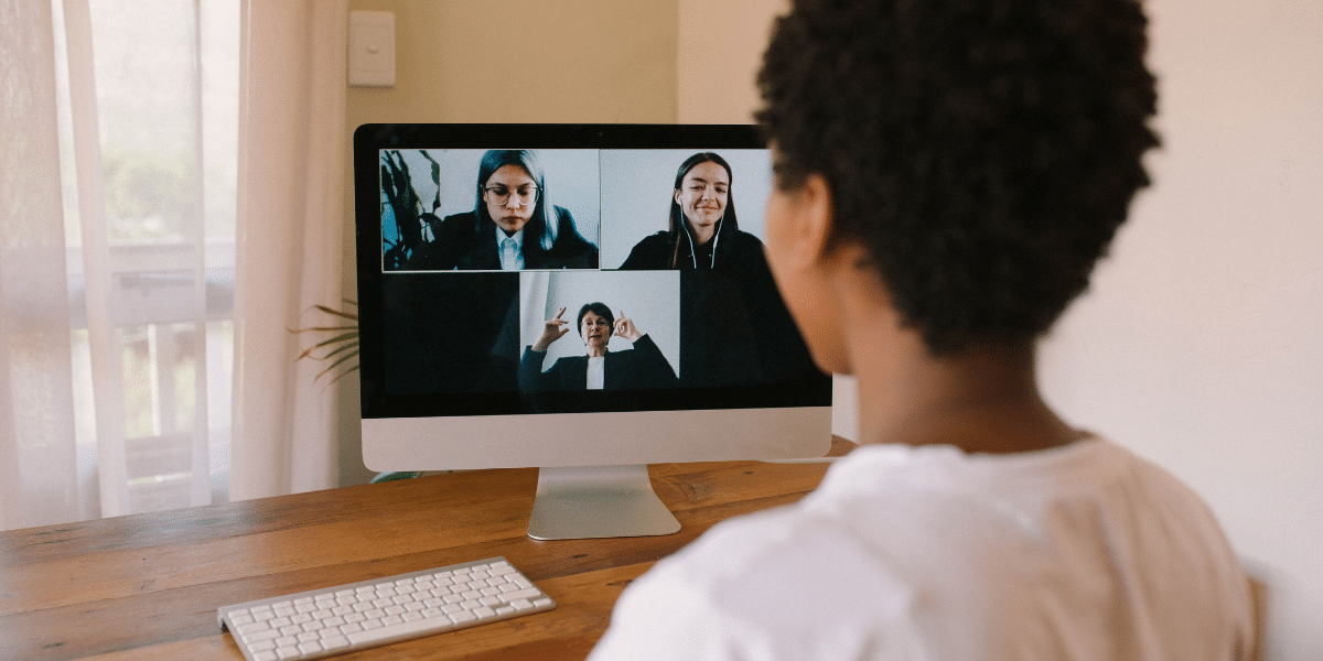 female sat at desk in remote meeting