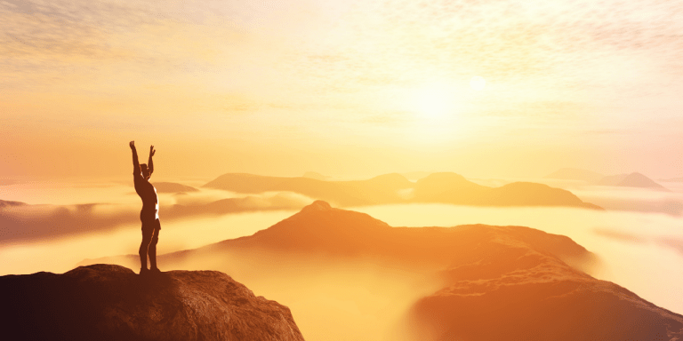 person on top of mountain at sunset