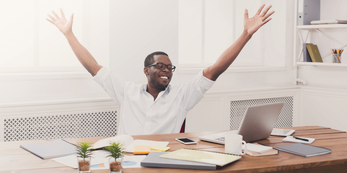 man in chair with arms up celebrating