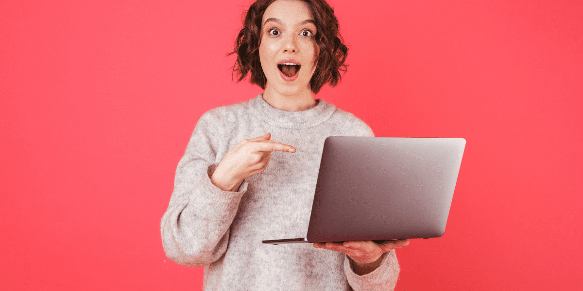 woman pointing at laptop and smiling