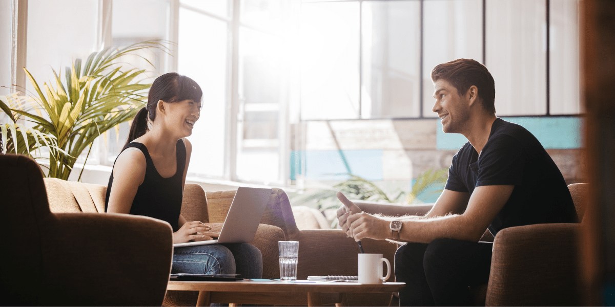 two people chatting and smiling on sofas