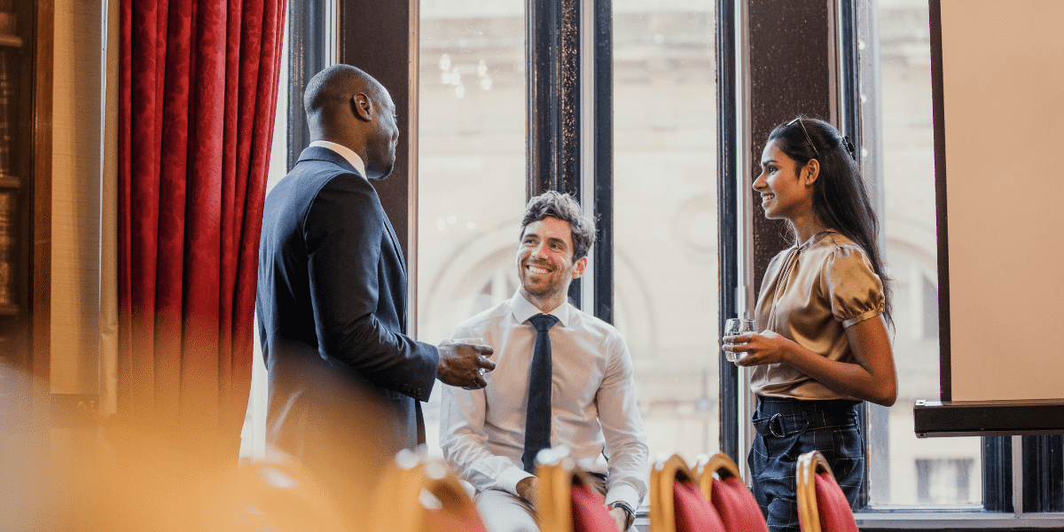 three colleagues having a conversation and smiling