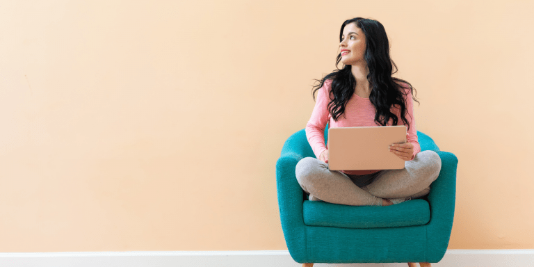 woman sat on sofa with laptop