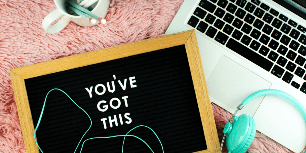 Letter board reading "You've got this" next to a laptop and turquoise headphones