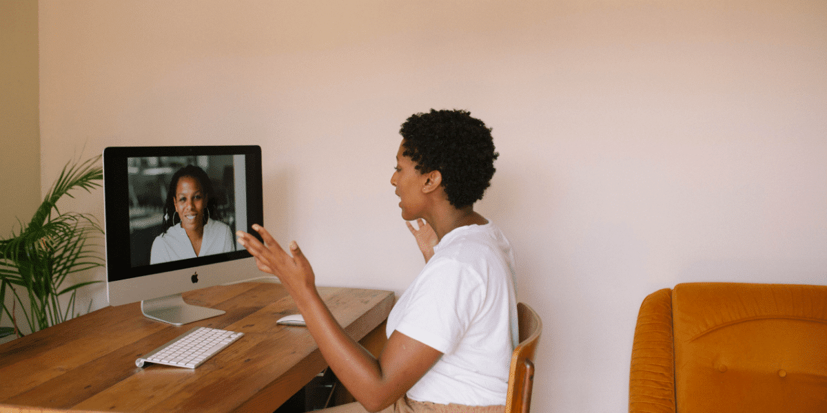 A woman talking mid-sentence to another woman on a video conference call in what could be an interview setting