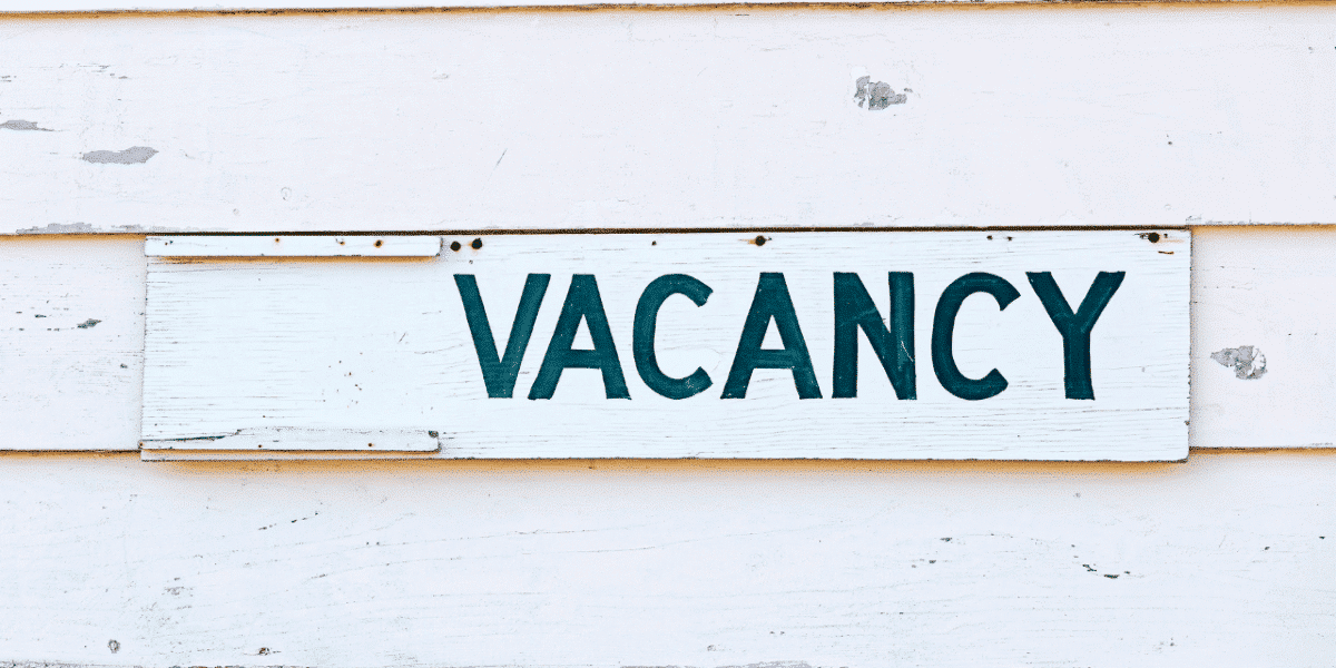 Bright VACANCY sign on a slatted wooden background