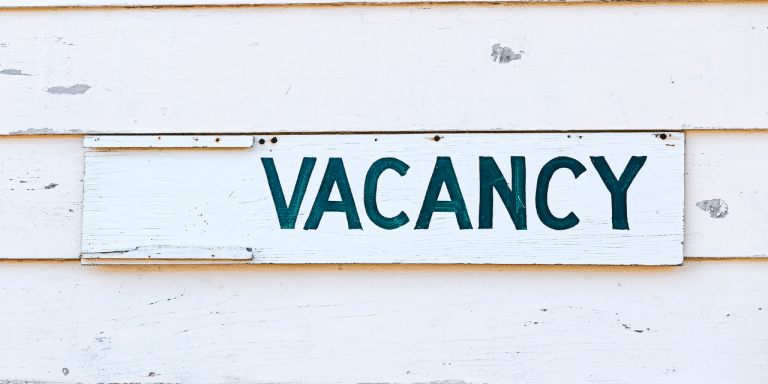 Bright VACANCY sign on a slatted wooden background