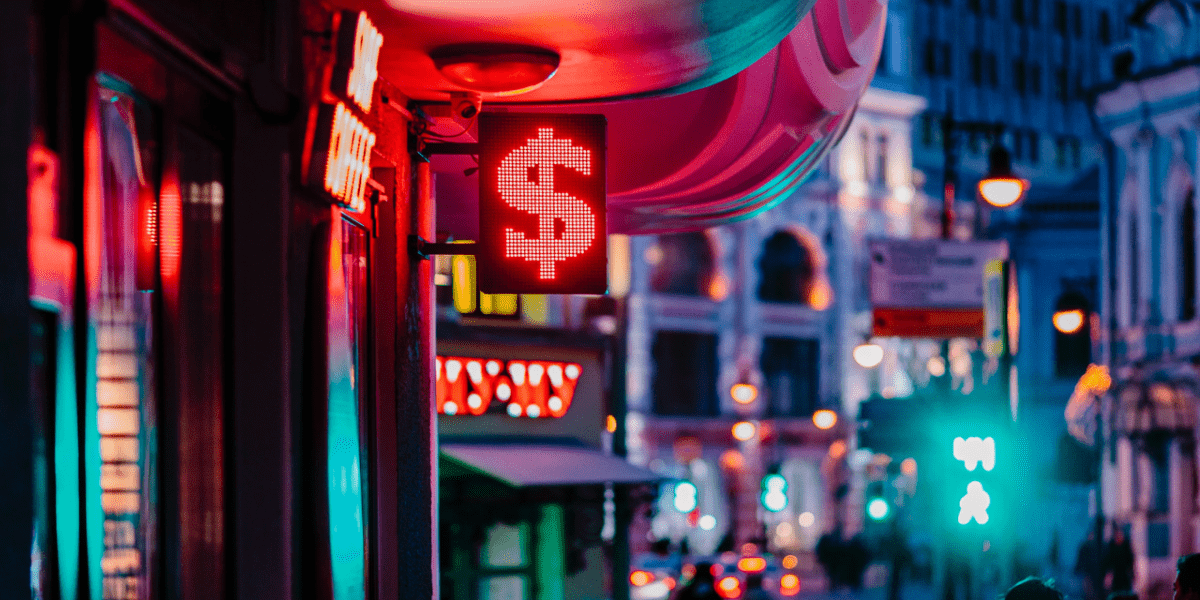 A neon street sign with the dollar sign