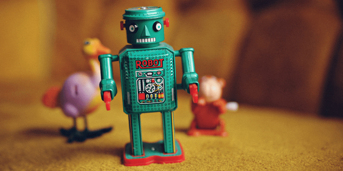 Vintage green tin toy robot labelled "Robot" standing in front of blurred toy animals