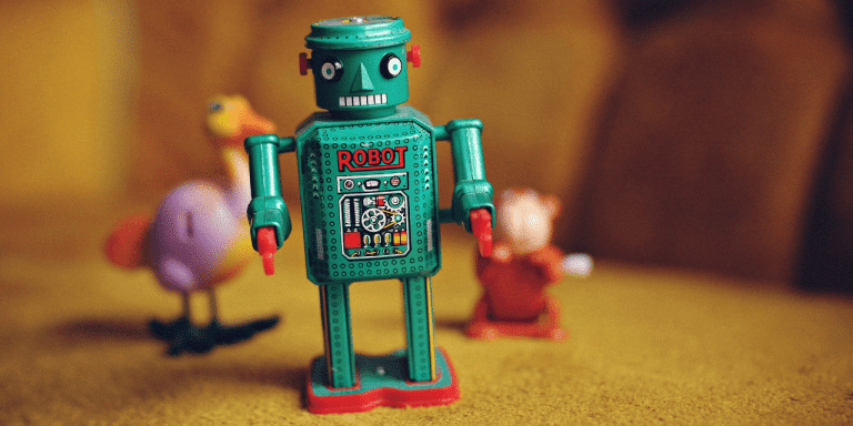 Vintage green tin toy robot labelled "Robot" standing in front of blurred toy animals