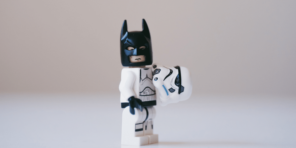 A lego Stormtrooper, holding his helmet in one hand revealing that he's actually Batman.