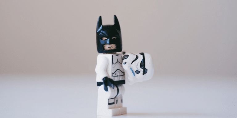 A lego Stormtrooper, holding his helmet in one hand revealing that he's actually Batman.