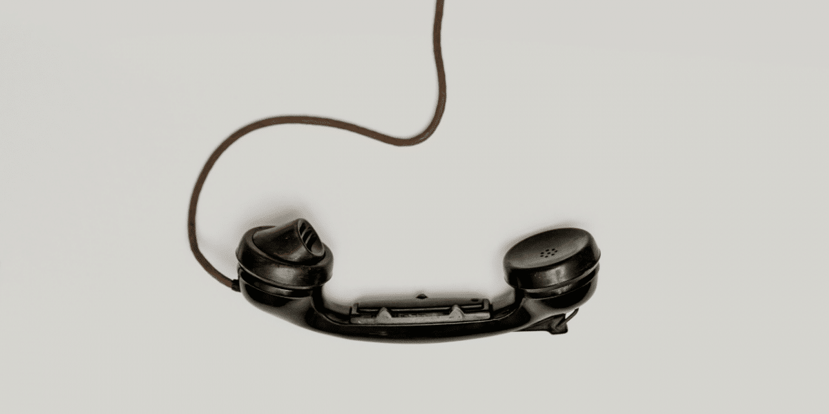 An old fashioned, black phone hanging off the hook