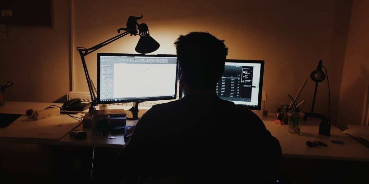 Man stares at two screens while working from home
