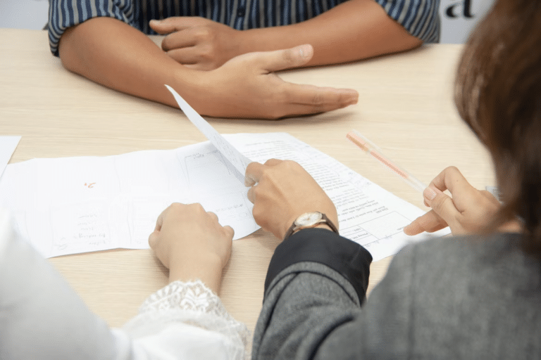 Recruiter and candidate review printed documents across a table during an interview