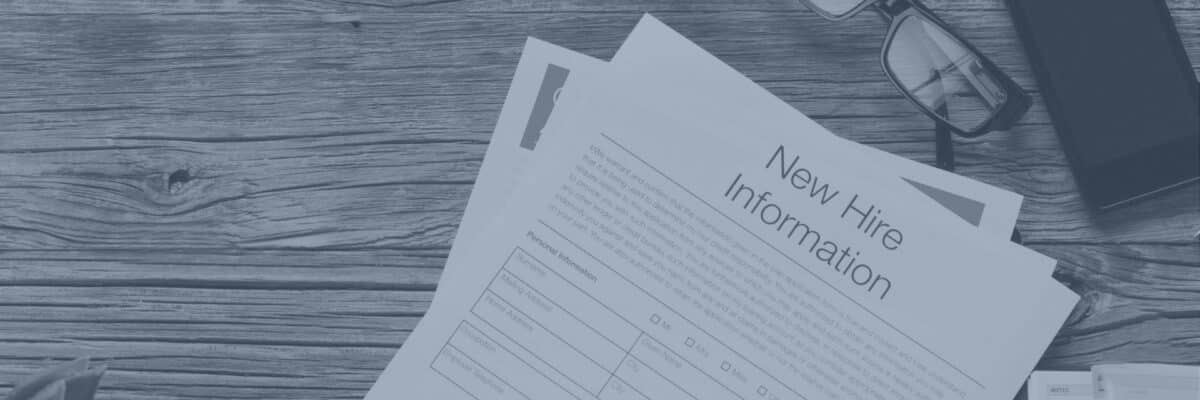 New Hire Information form on a wooden desk beside glasses and a phone, in a blue-tinted banner