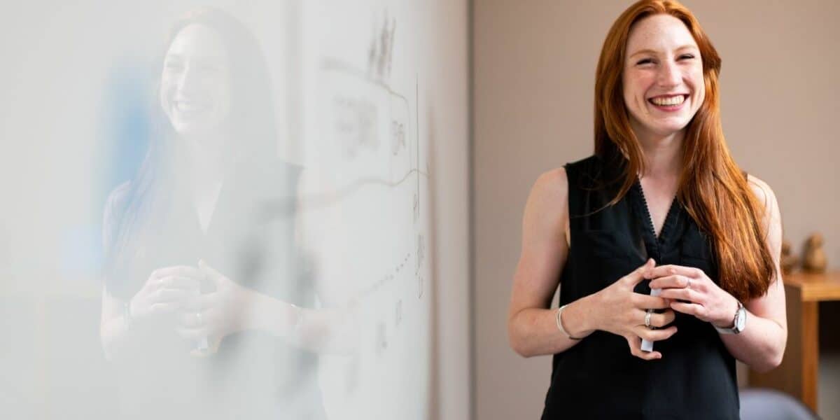 Woman stands in front of whiteboard in customer education effort