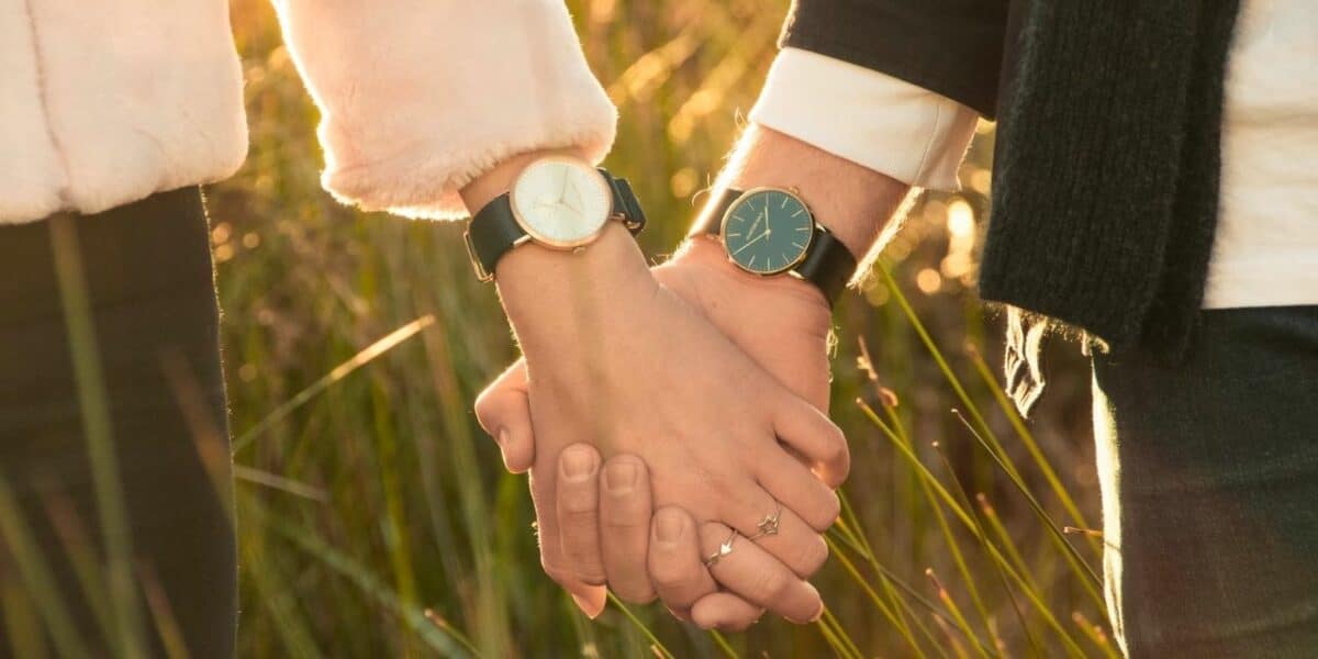 Couple's hands holding, both wearing watches