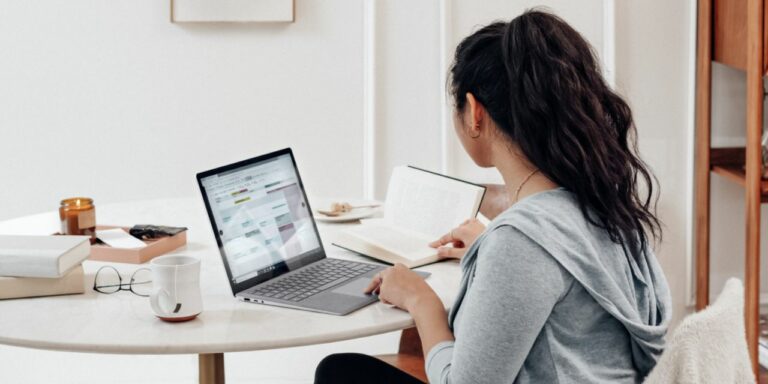 A woman typing on her laptop in her home set up.