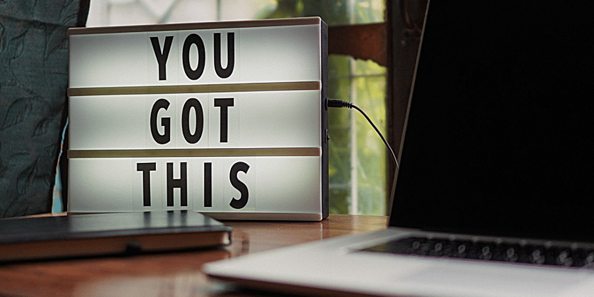 A light box with letters reading 'YOU GOT THIS' on a desk, next to a laptop