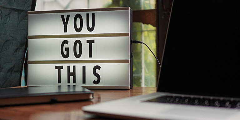 A light box with letters reading 'YOU GOT THIS' on a desk, next to a laptop