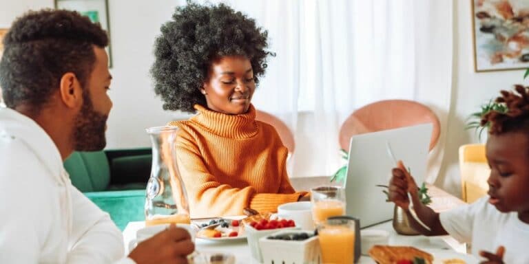 woman smiling with laptop at table