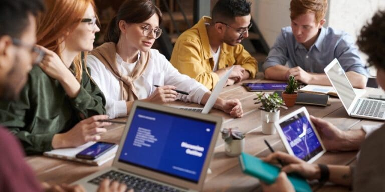 TextExpander team members working together at a table with laptops and tablets